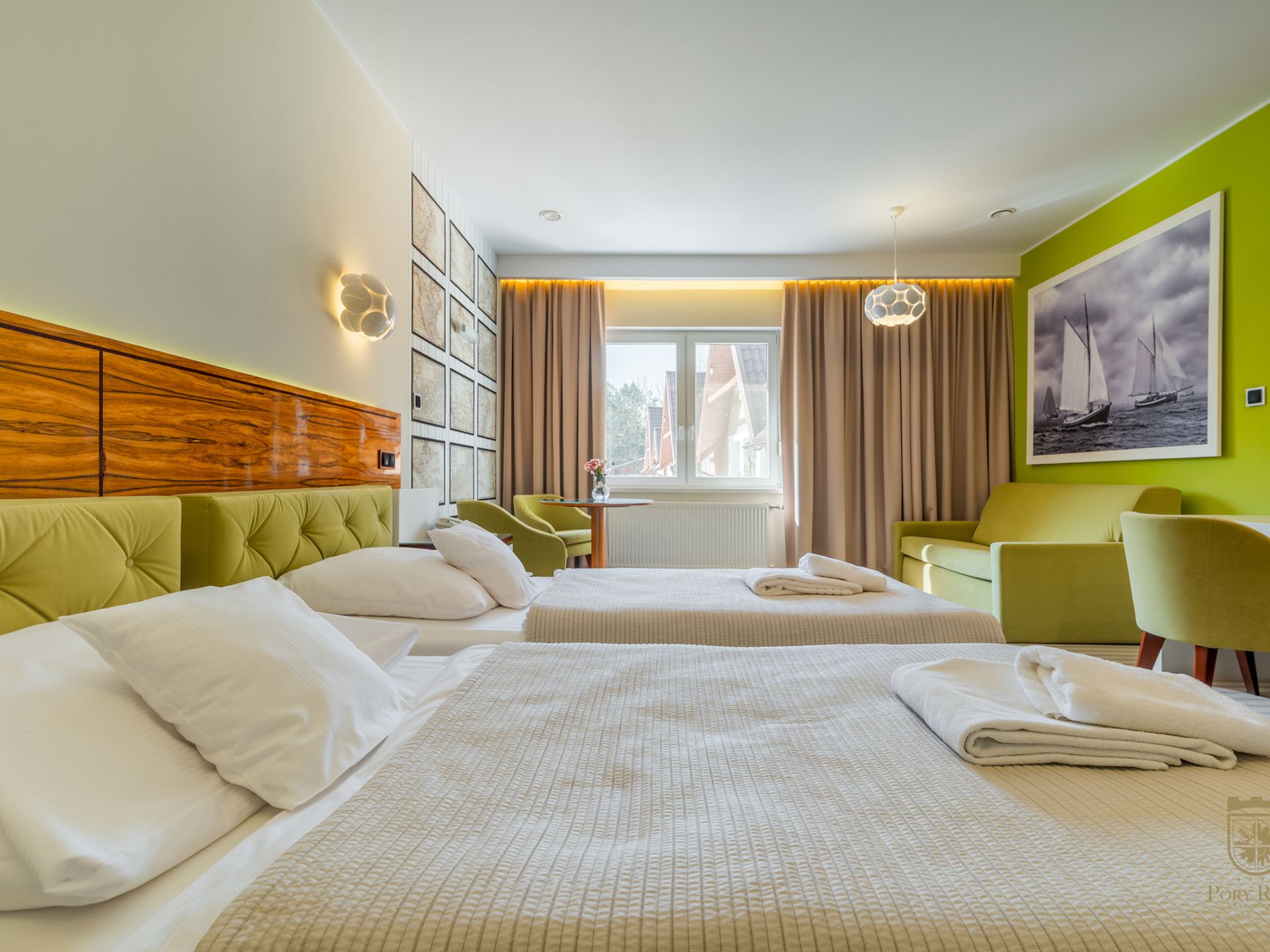 Pokój z dwoma łóżkami i zielonymi fotelami w Hotelu Pory Roku